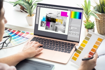 Person working on a laptop with a graphic design p